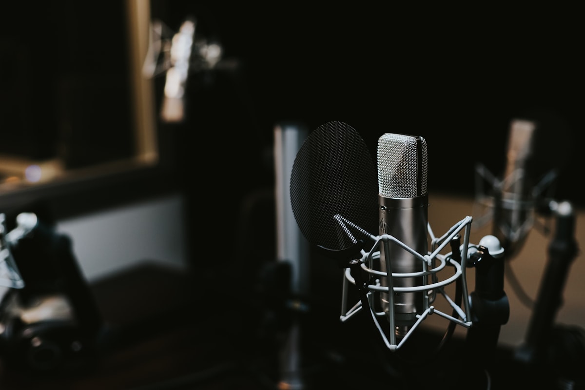 Audio editing software showing waveform display on a wide monitor in a home studio setup